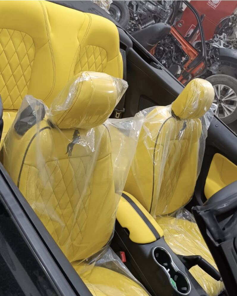 Ford Mustang convertible with yellow quilted leather seats, armrest and door panel, still in protective wrap