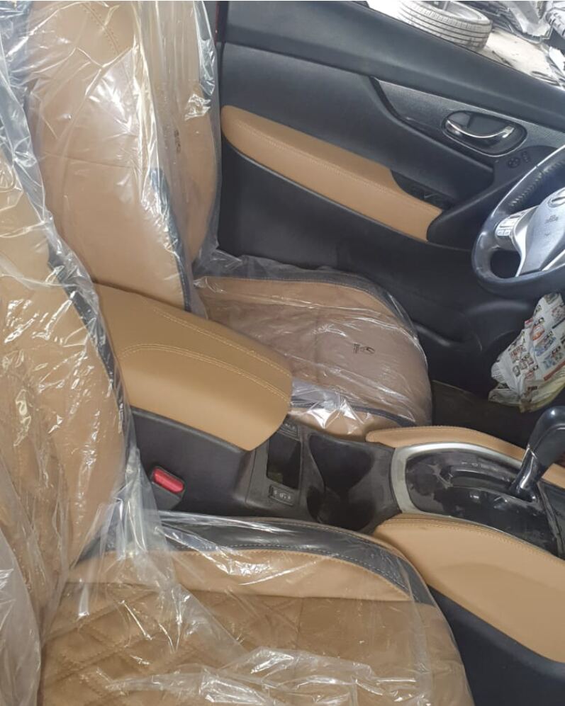 Nissan Rogue with tan leather seats, armrest and door trim, still wrapped after upholstery