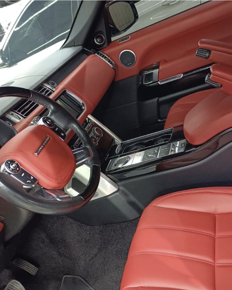 Range Rover interior in red leather covering seats, dashboard, door panels and steering wheel airbag cover